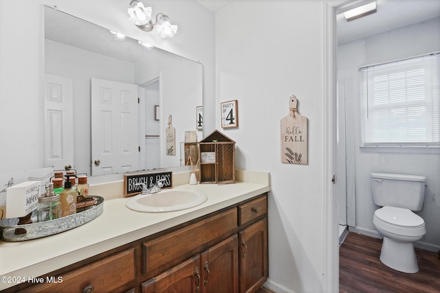 bathroom featuring toilet, vanity, and hardwood / wood-style flooring