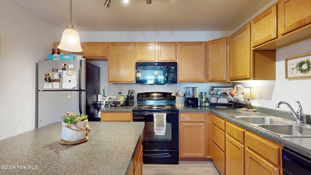 kitchen featuring sink, black appliances, and decorative light fixtures