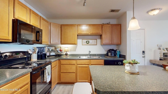 kitchen with pendant lighting, sink, a center island, and black appliances