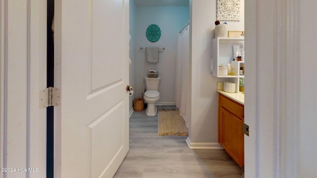 bathroom featuring hardwood / wood-style floors, vanity, a shower with shower curtain, and toilet