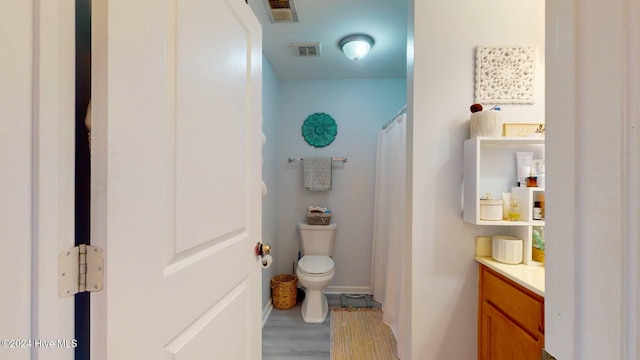 bathroom with hardwood / wood-style flooring, vanity, and toilet