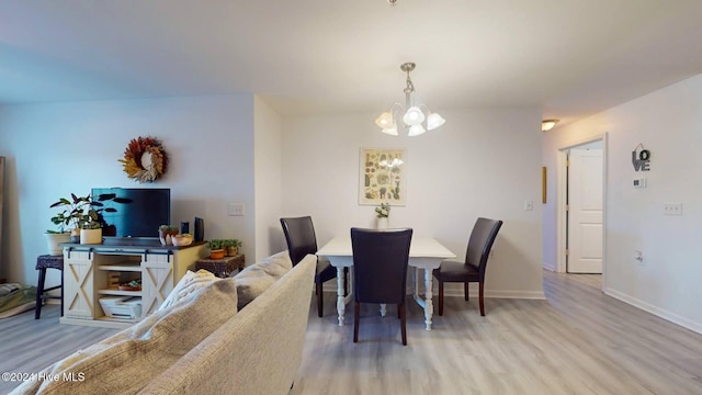 dining area with hardwood / wood-style floors and an inviting chandelier