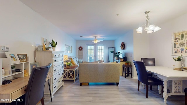 interior space featuring ceiling fan with notable chandelier, light hardwood / wood-style floors, and french doors