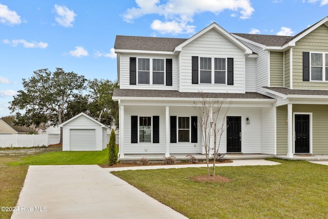 view of front of property with covered porch, a garage, an outdoor structure, and a front lawn