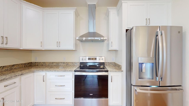 kitchen featuring white cabinets, appliances with stainless steel finishes, light stone countertops, and wall chimney range hood