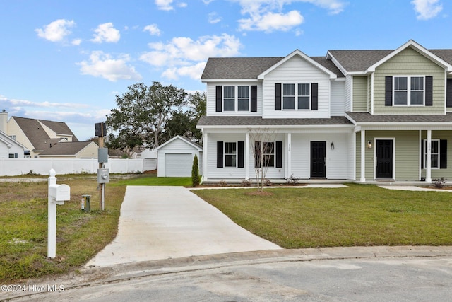 view of front of house with covered porch, a garage, a front lawn, and an outdoor structure