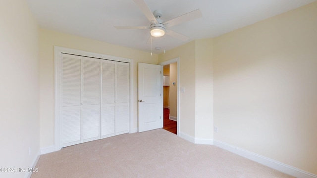 unfurnished bedroom with carpet, a closet, and ceiling fan