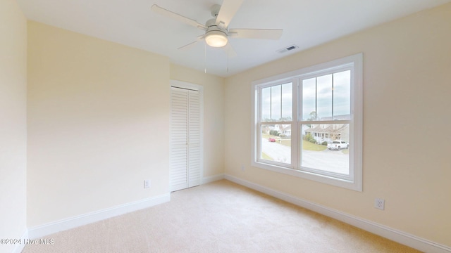 carpeted spare room with ceiling fan