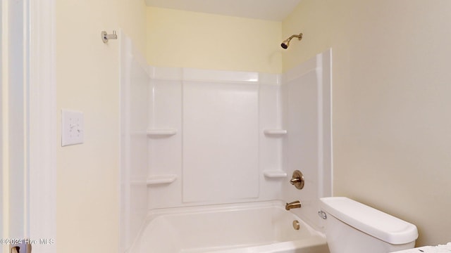 bathroom featuring tub / shower combination and toilet