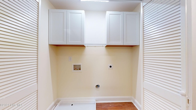 washroom with cabinets, hookup for a washing machine, light hardwood / wood-style flooring, and electric dryer hookup