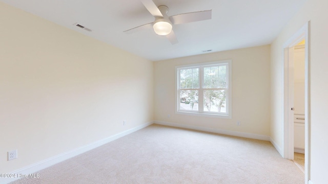 carpeted spare room featuring ceiling fan