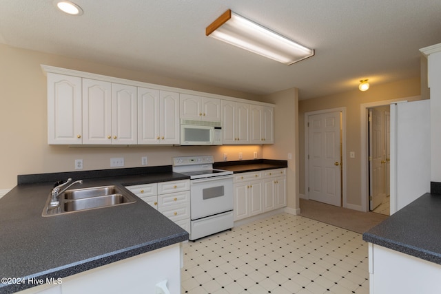 kitchen featuring white cabinets, white appliances, kitchen peninsula, and sink