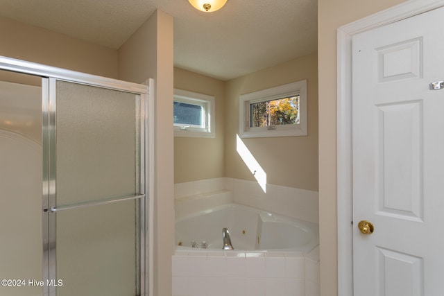 bathroom with separate shower and tub and a textured ceiling