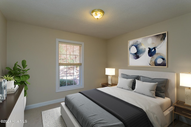 bedroom with light carpet and a textured ceiling