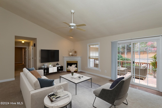 living room with a textured ceiling, light colored carpet, a wealth of natural light, and ceiling fan