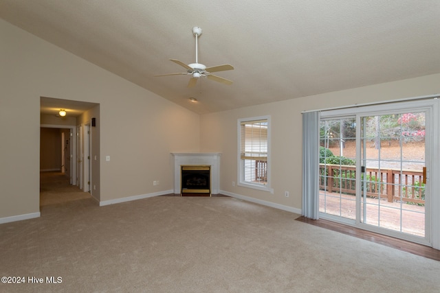 unfurnished living room with light colored carpet, plenty of natural light, lofted ceiling, and ceiling fan