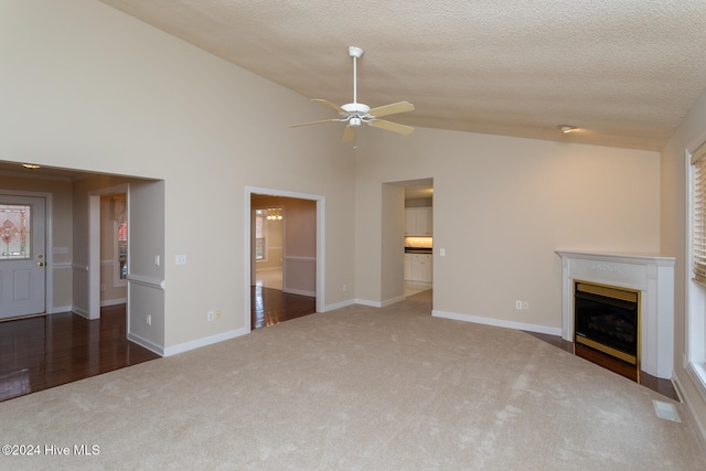 unfurnished living room featuring ceiling fan, dark carpet, a textured ceiling, and high vaulted ceiling