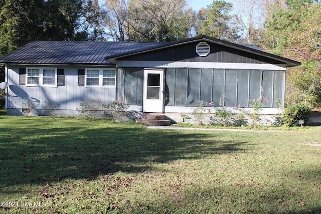 single story home with a sunroom and a front lawn