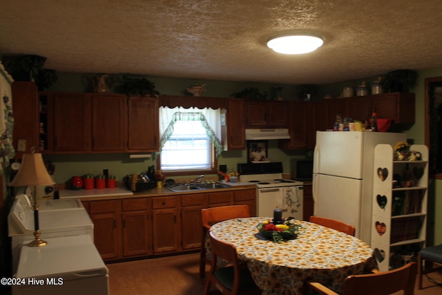 kitchen featuring a textured ceiling, white appliances, and sink