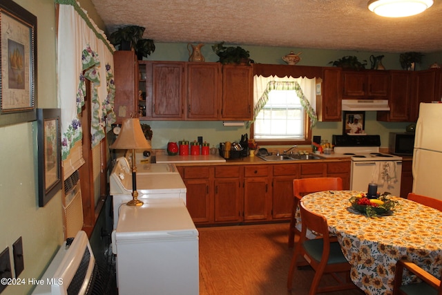 kitchen with hardwood / wood-style flooring, white appliances, sink, and a textured ceiling