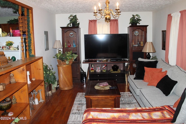 living room with a notable chandelier, a textured ceiling, and dark wood-type flooring