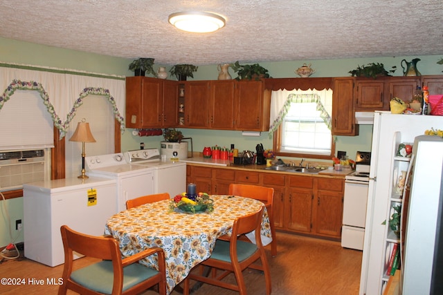 kitchen with hardwood / wood-style floors, washer and dryer, sink, and a textured ceiling