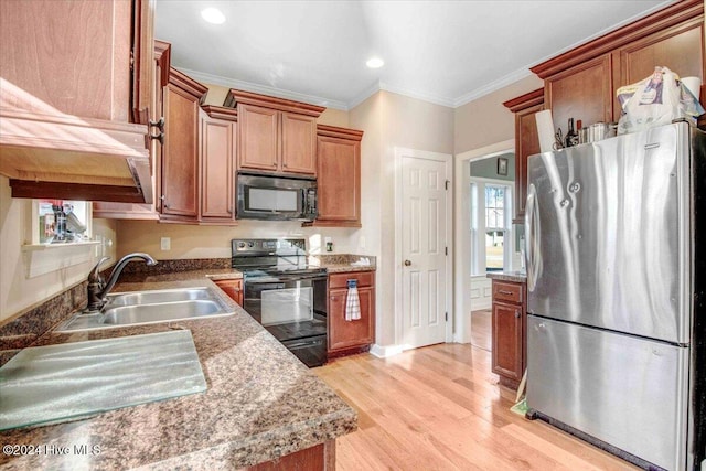 kitchen featuring light wood-type flooring, sink, ornamental molding, and black appliances