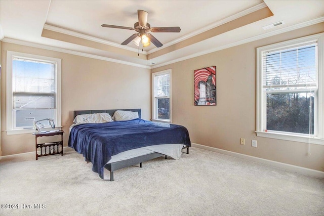 bedroom featuring a raised ceiling, ceiling fan, light carpet, and ornamental molding