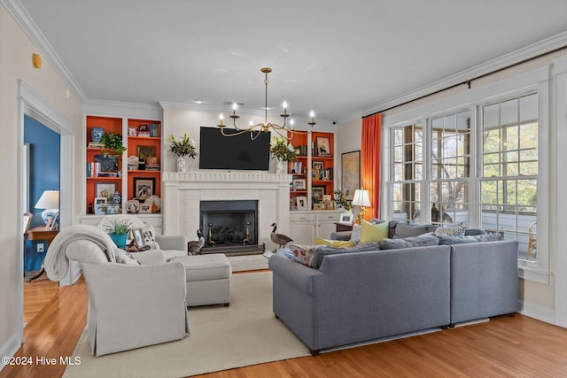 living room featuring a fireplace, crown molding, light hardwood / wood-style flooring, and a chandelier