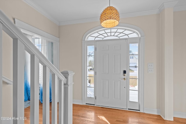 foyer with light hardwood / wood-style floors and crown molding