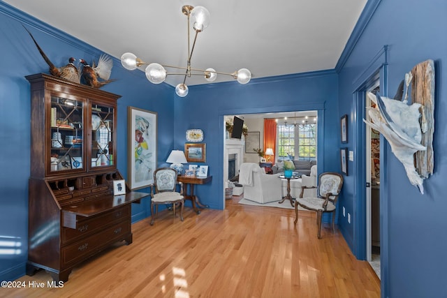 interior space featuring a notable chandelier, ornamental molding, and light hardwood / wood-style flooring