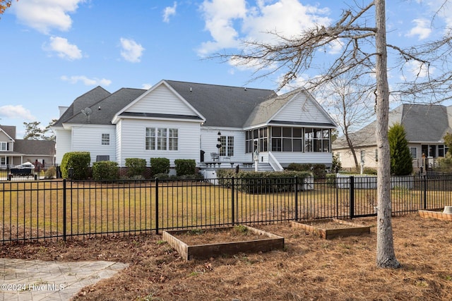 rear view of property with a lawn and a sunroom