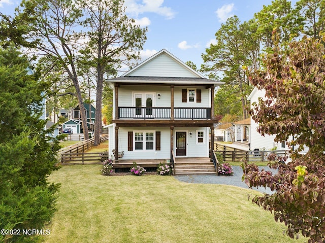 view of front of property featuring a balcony, covered porch, and a front yard