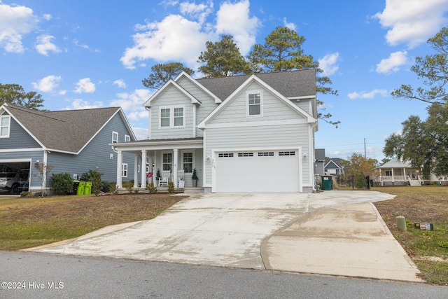 front of property featuring a porch, a garage, and a front lawn