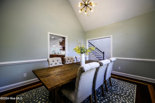 dining space featuring a chandelier, hardwood / wood-style flooring, high vaulted ceiling, and sink