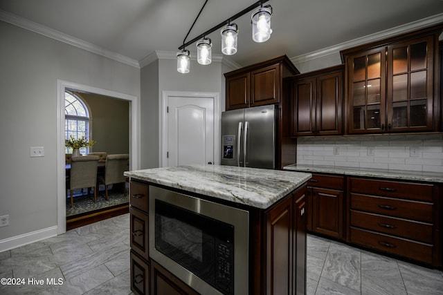 kitchen with dark brown cabinetry, built in microwave, stainless steel refrigerator with ice dispenser, backsplash, and pendant lighting