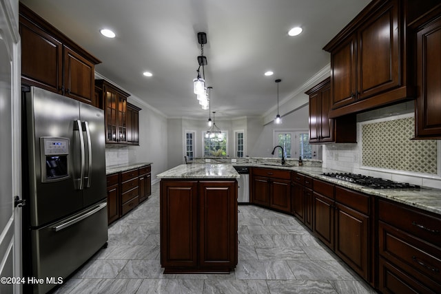 kitchen featuring tasteful backsplash, a center island, pendant lighting, and appliances with stainless steel finishes