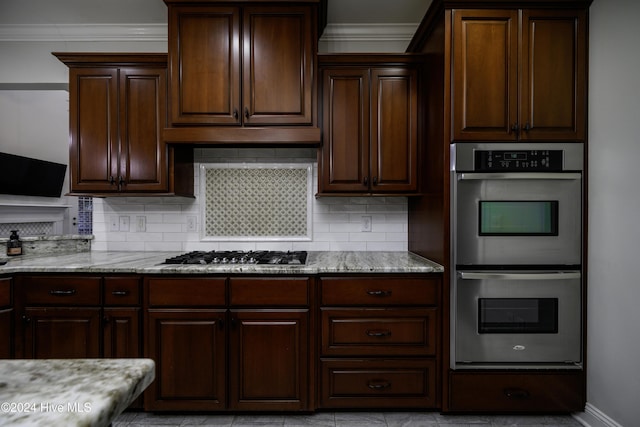 kitchen featuring tasteful backsplash, light stone counters, dark brown cabinets, and stainless steel appliances