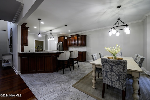 dining room with ornamental molding and sink