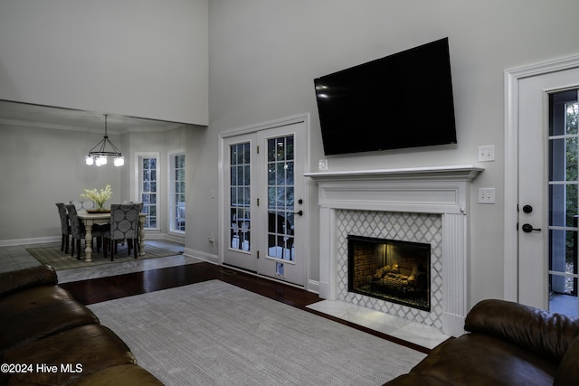 living room featuring a notable chandelier, dark hardwood / wood-style floors, plenty of natural light, and a tiled fireplace