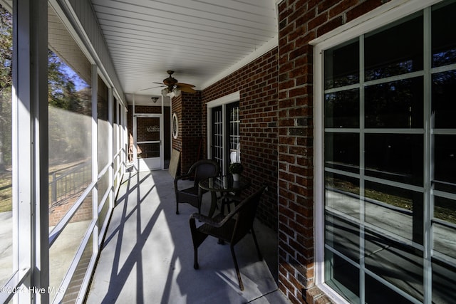 unfurnished sunroom featuring ceiling fan