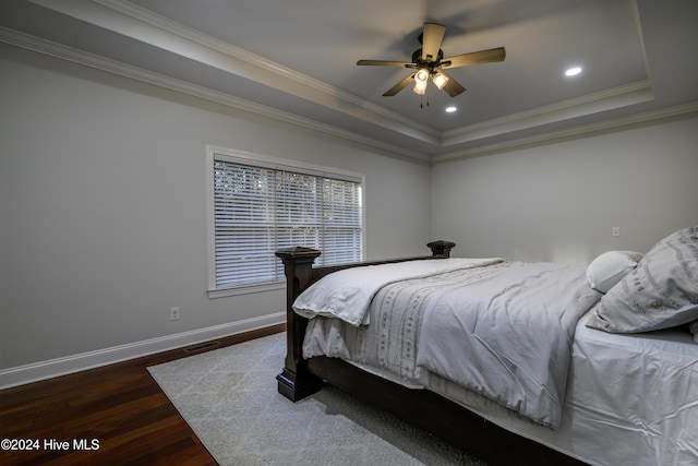 bedroom with ceiling fan, dark hardwood / wood-style floors, ornamental molding, and a tray ceiling