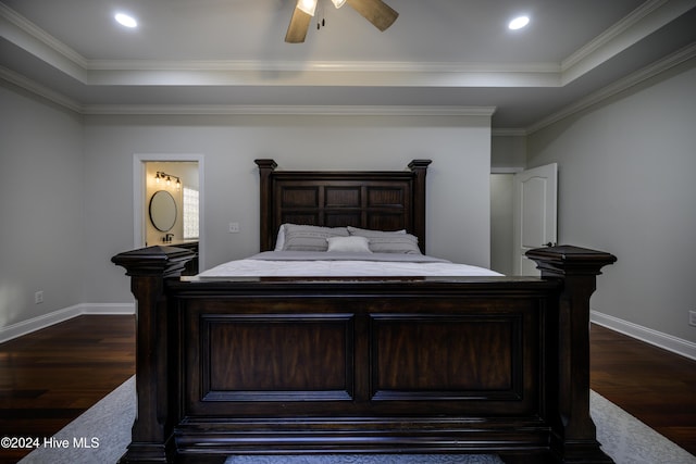 bedroom with ceiling fan, dark hardwood / wood-style flooring, crown molding, and a tray ceiling