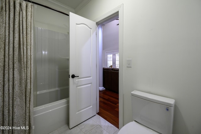 bathroom featuring tile patterned floors, toilet, ornamental molding, and shower / tub combo with curtain