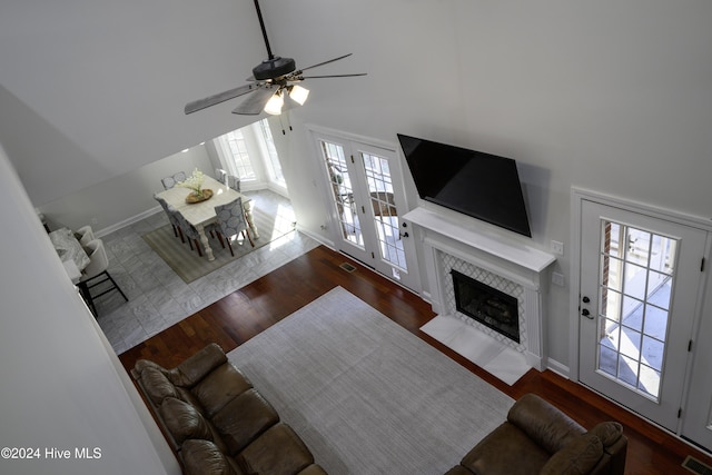 living room with dark hardwood / wood-style flooring, ceiling fan, plenty of natural light, and a high end fireplace