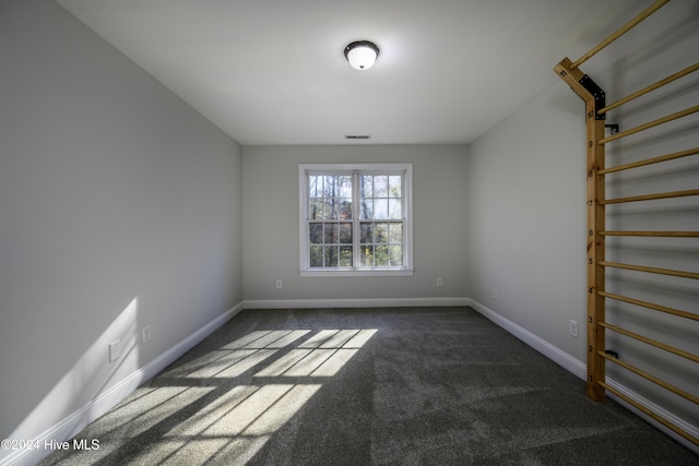 spare room featuring dark carpet