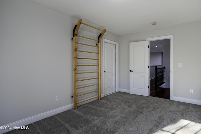 unfurnished bedroom featuring dark carpet