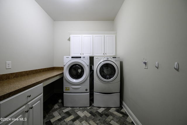 laundry room featuring separate washer and dryer and cabinets