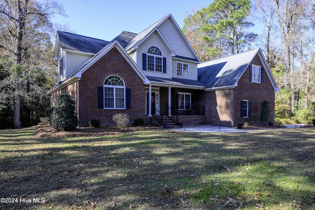 front facade featuring a porch, a patio, and a front lawn