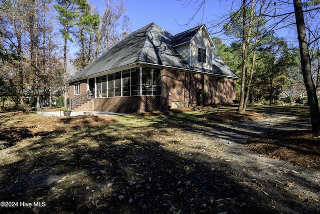 view of home's exterior with a sunroom